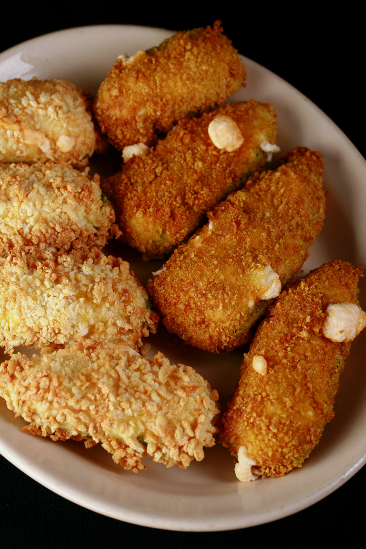 A small ivory colour plate holds two different types of gluten-free jalapeno poppers.