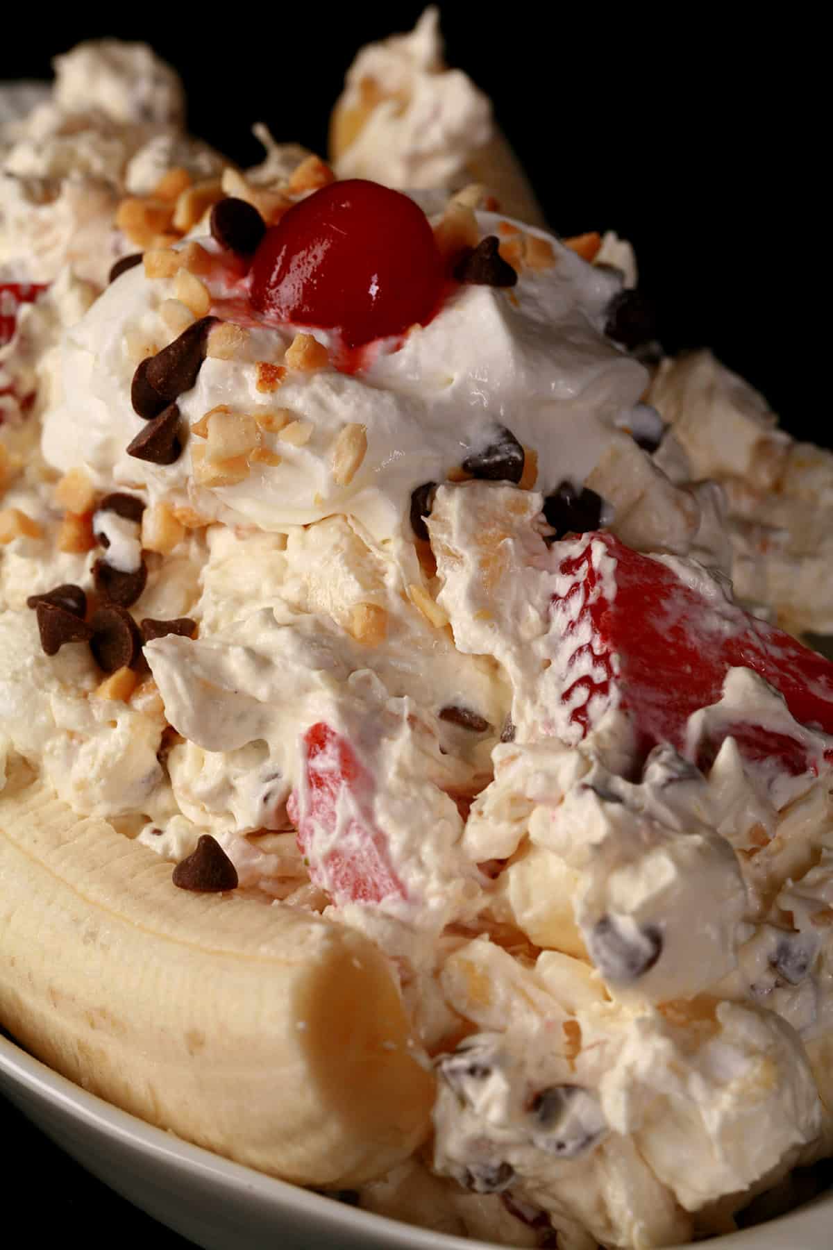A large serving of banana split marshmallow salad, done up to look like a banana split.