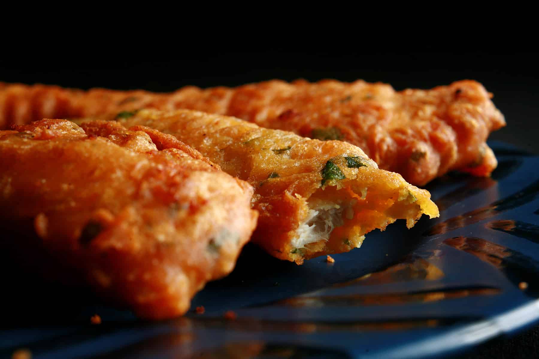 Several chicken pakoras on a blue plate.