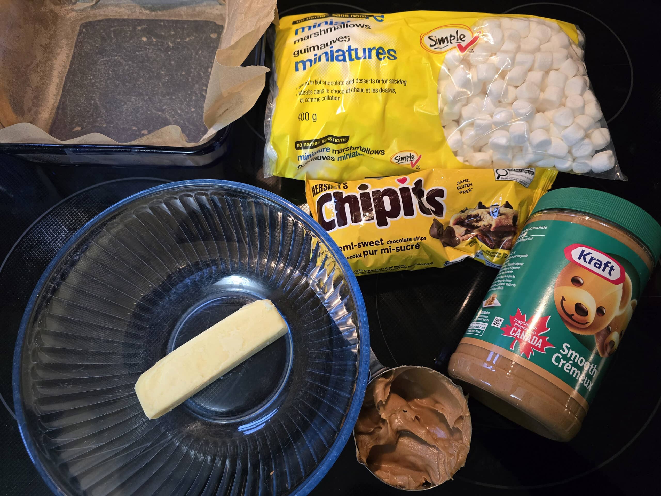 All of the chocolate peanut butter confetti bar ingredients laid out on a stove.
