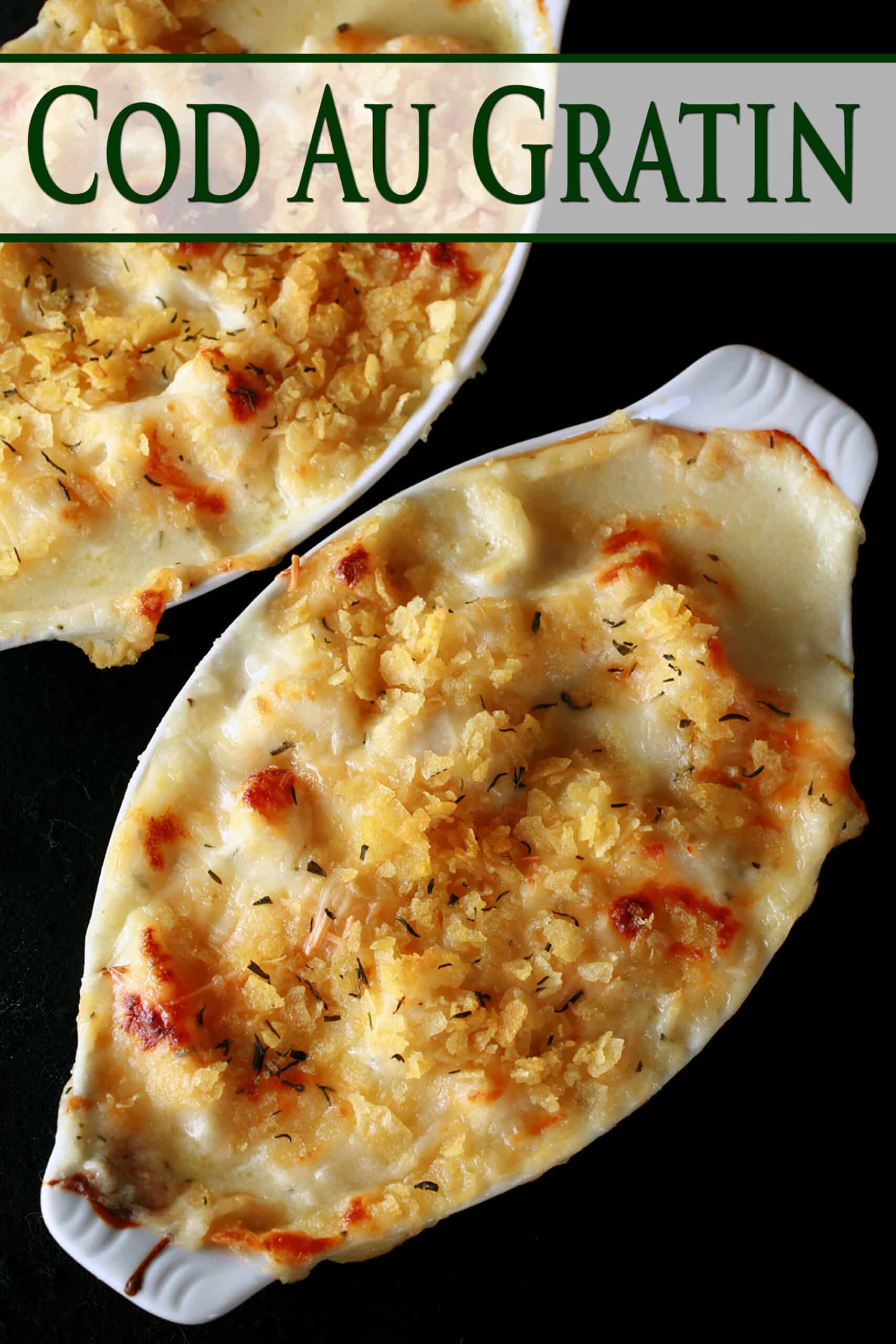 Two oblong ceramic ramekins of traditional cod au gratin. Cod is in a creamy, cheesy sauce, topped with crushed chips, more cheese, and savoury.