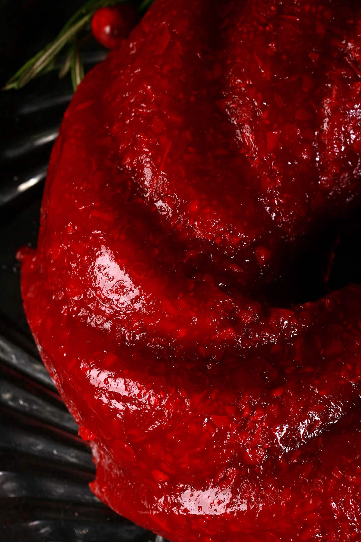 A molded cranberry Jello salad on a glass plate.