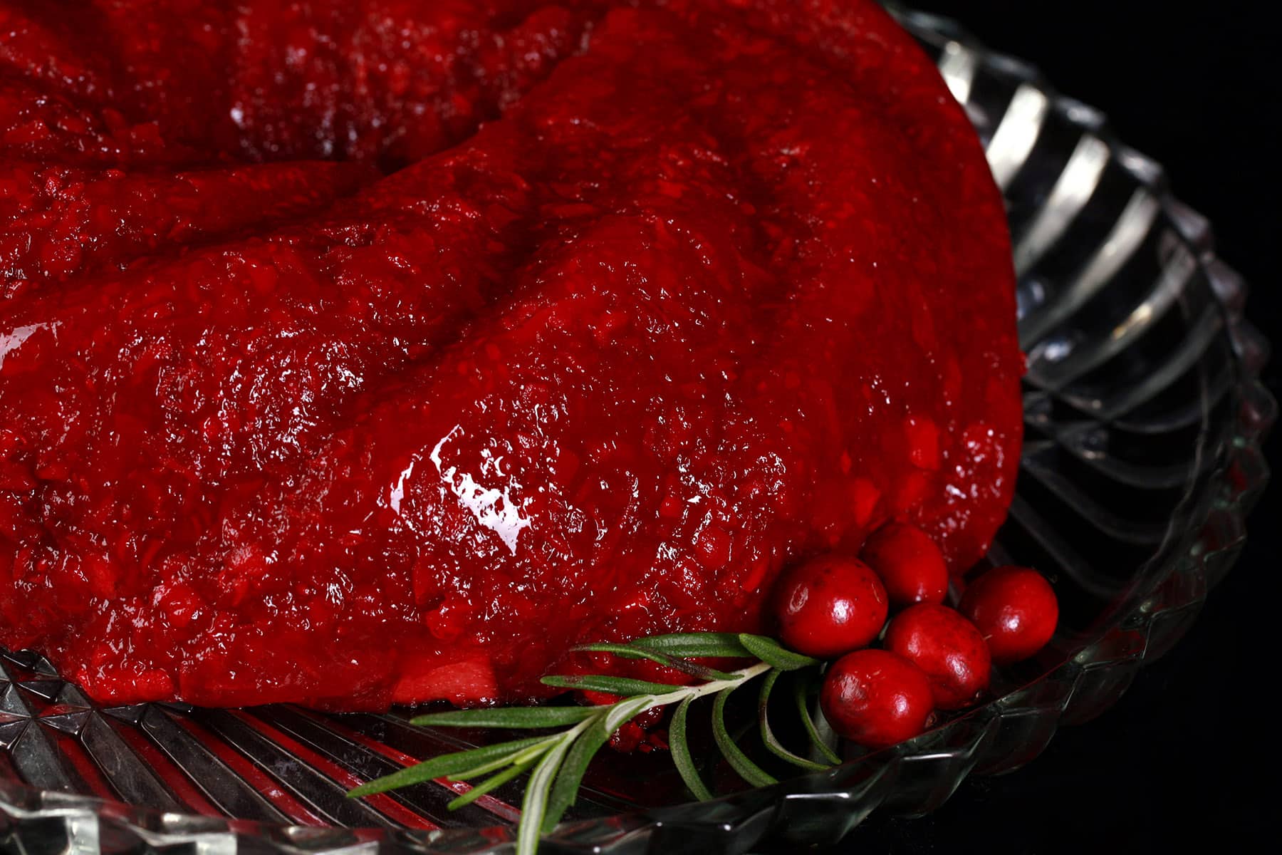 A molded cranberry Jello salad on a glass plate.