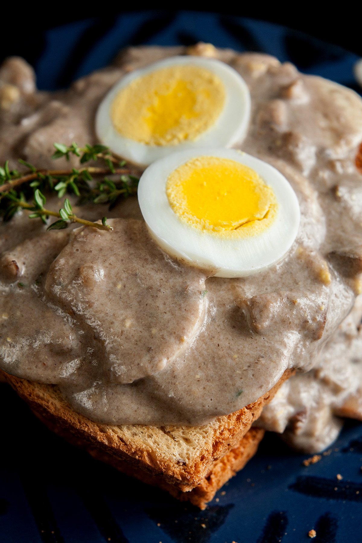 Gluten-Free Mushroom Soup and Eggs on Toast, garnished with hardboiled egg slices and thyme.
