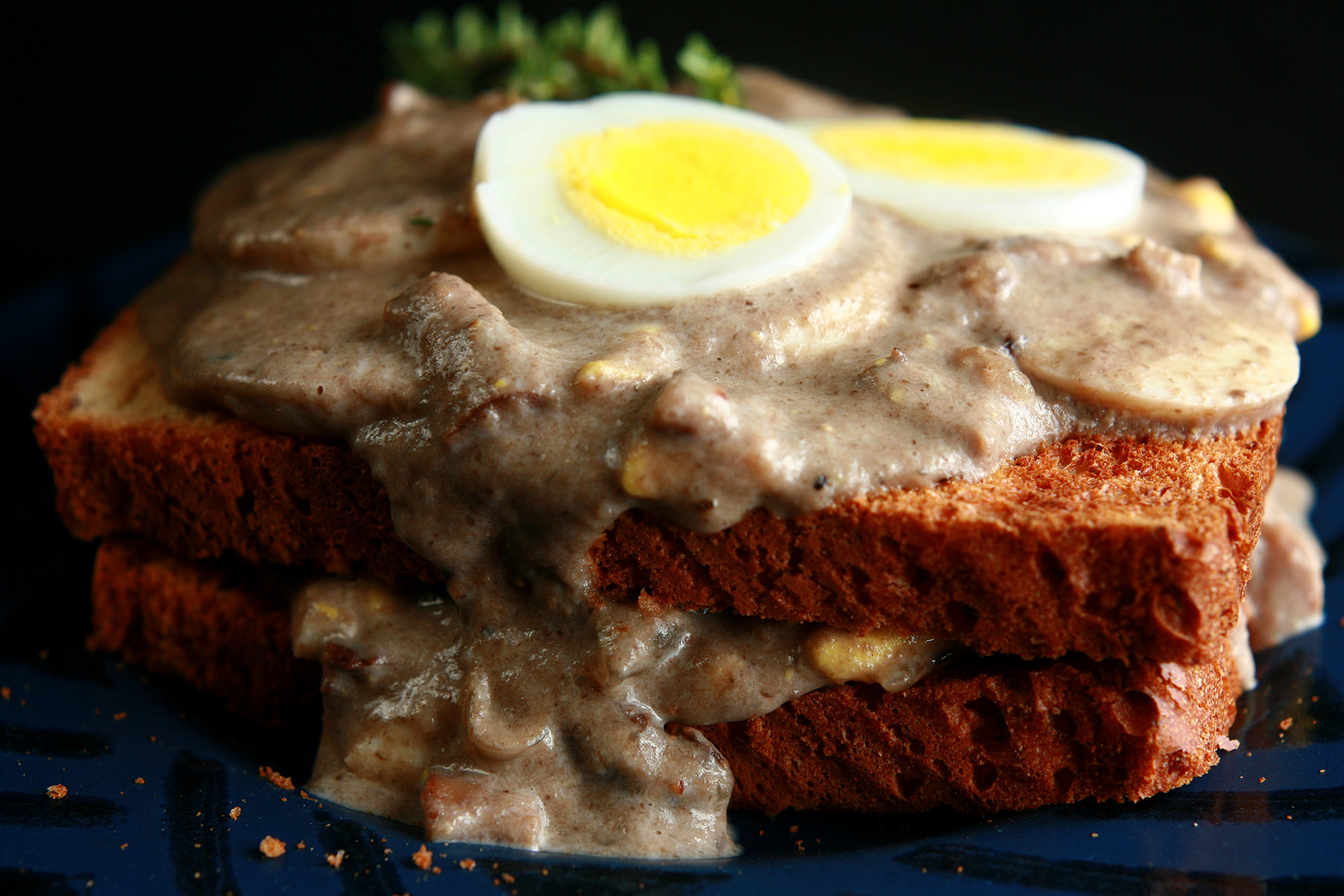 Gluten-Free Mushroom Soup and Eggs on Toast, garnished with hardboiled egg slices and thyme.