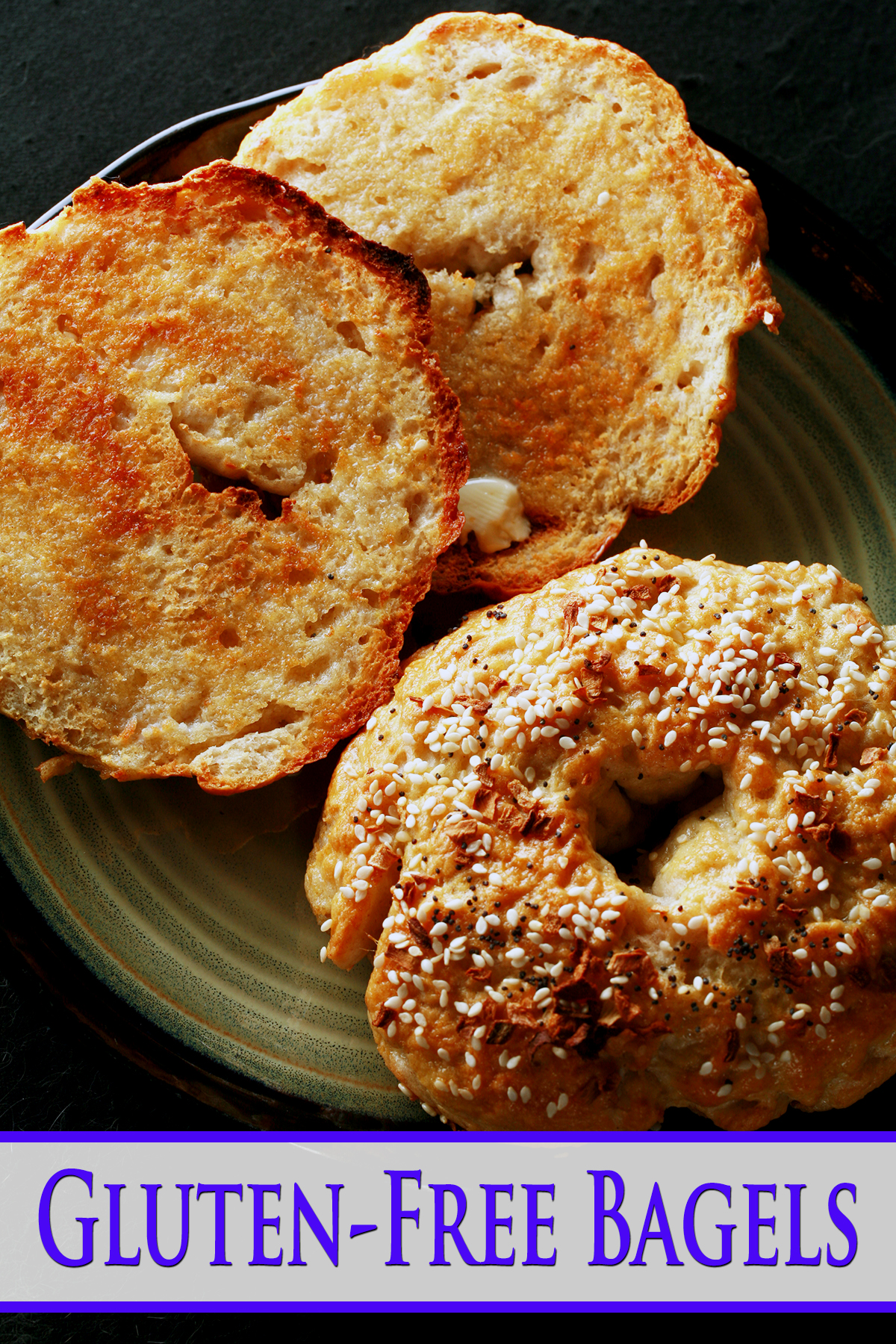 A close up view of two toasted gluten-free bagels on a plate. One is coated with everything seasoning.
