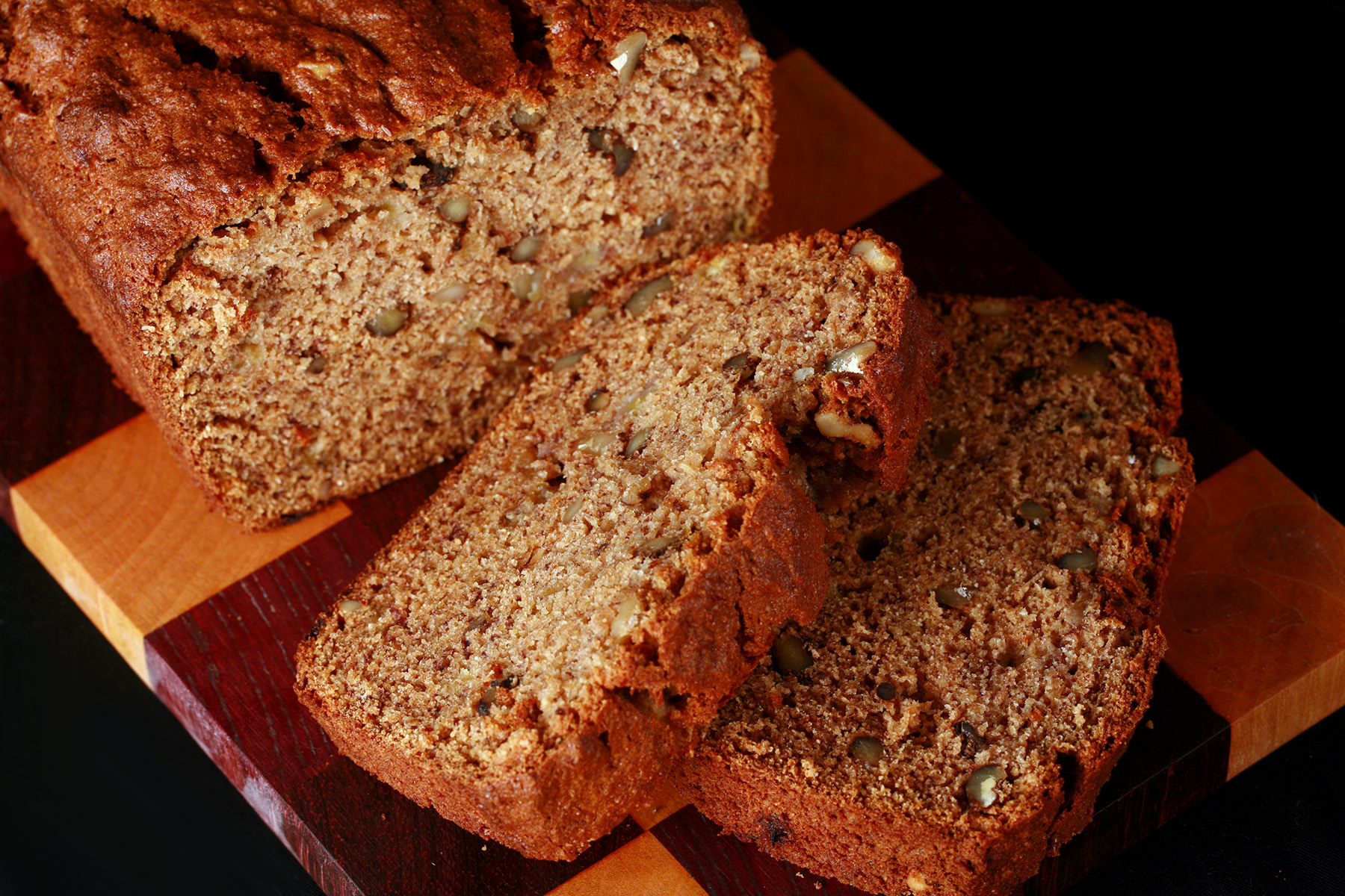 A loaf of gluten free banana bread, along with 2 slices cut from it.