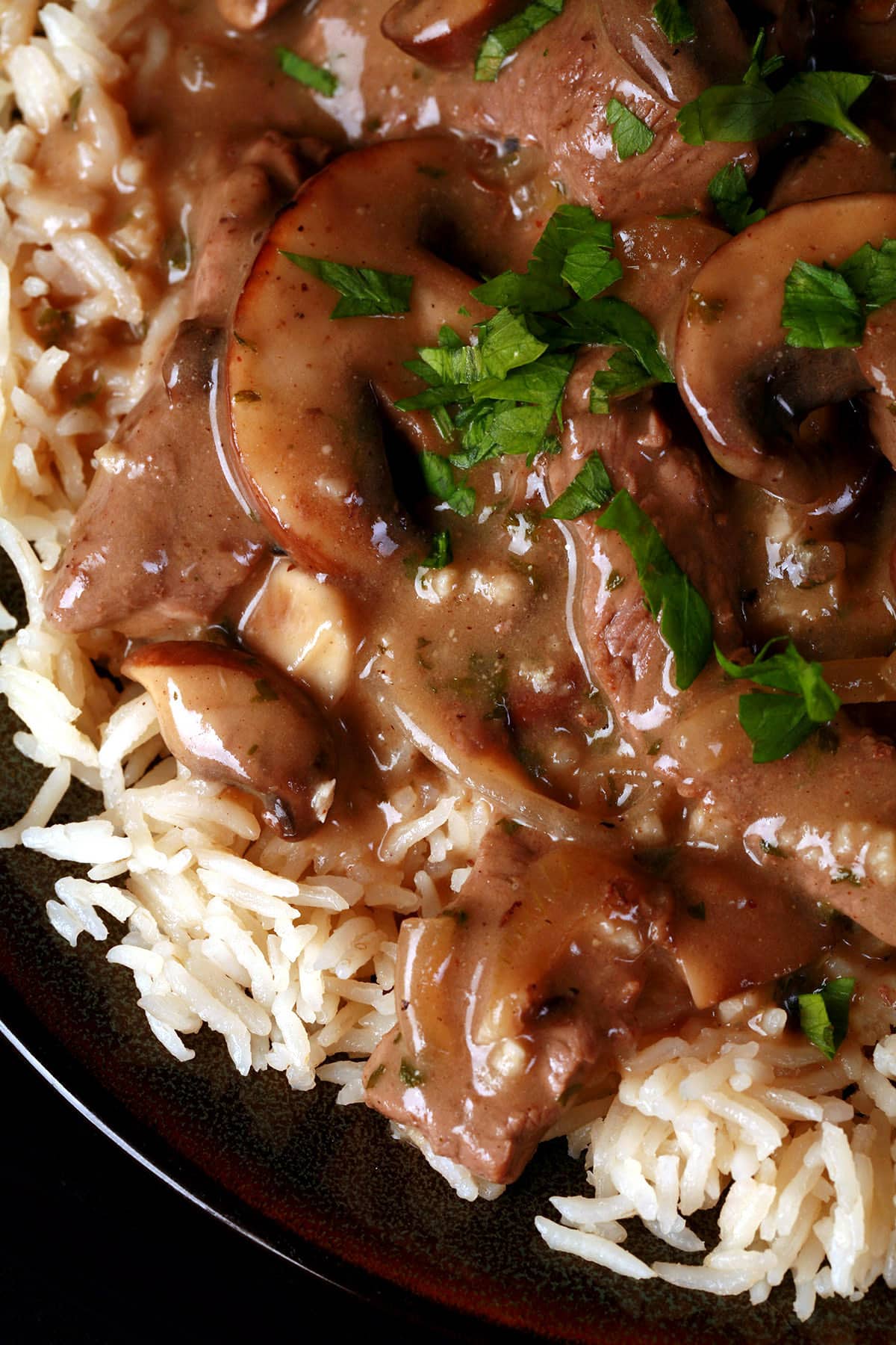 A serving of gluten free beef stroganoff over a bed of rice.