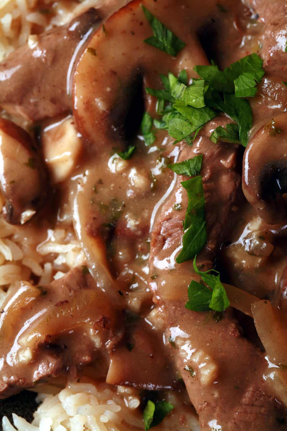 A serving of gluten free beef stroganoff over a bed of rice.