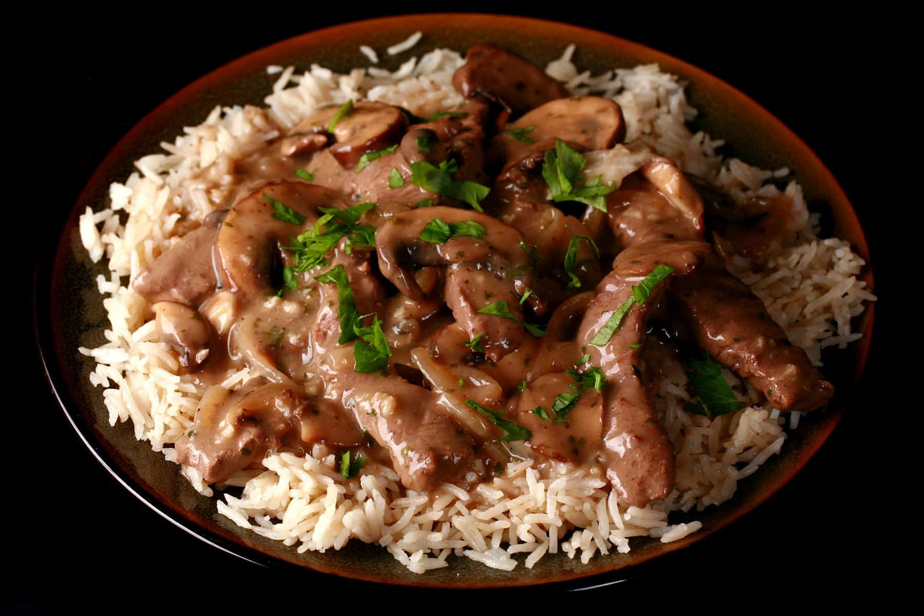 A serving of gluten-free beef stroganoff over a bed of rice.