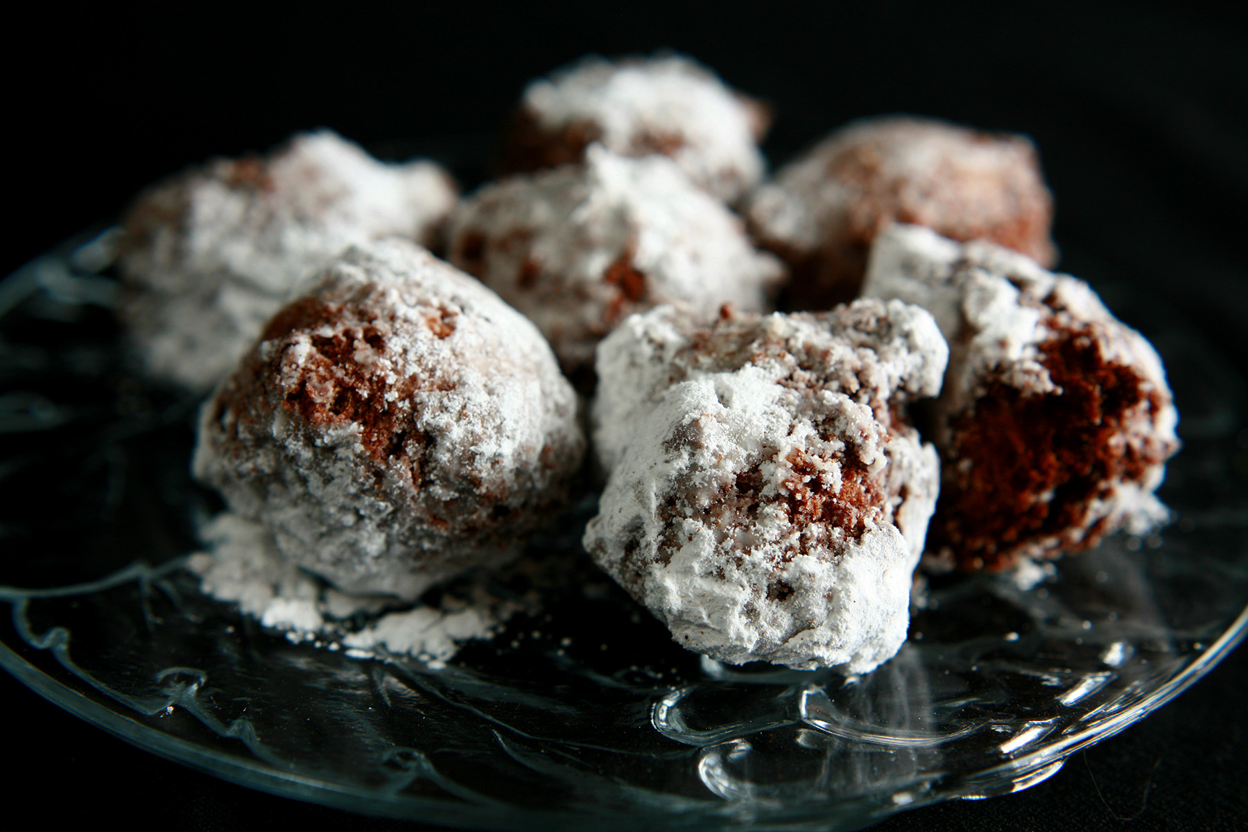 Several Gluten-Free Chai Doughnut Holes on a clear glass plate.