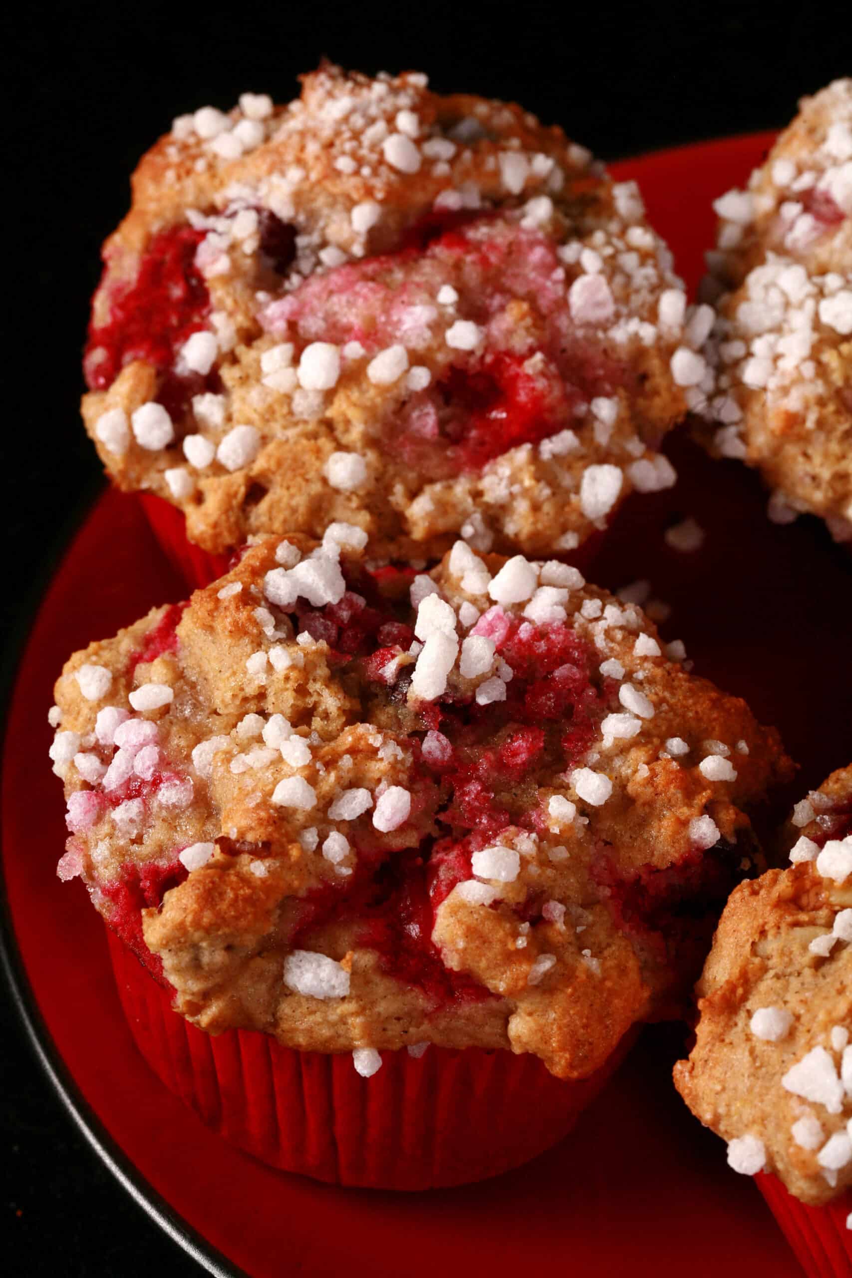 1 plate of gluten free cranberry walnut muffins with sugar crust on top.