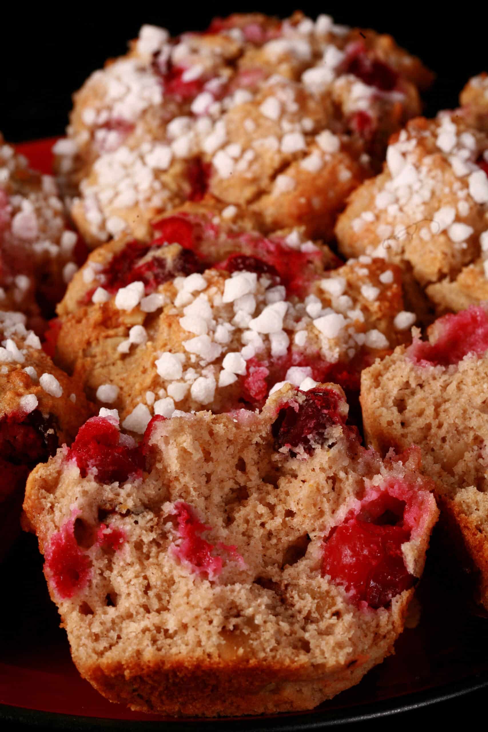 1 plate of gluten free cranberry muffins with walnuts and a sugar crust on top.