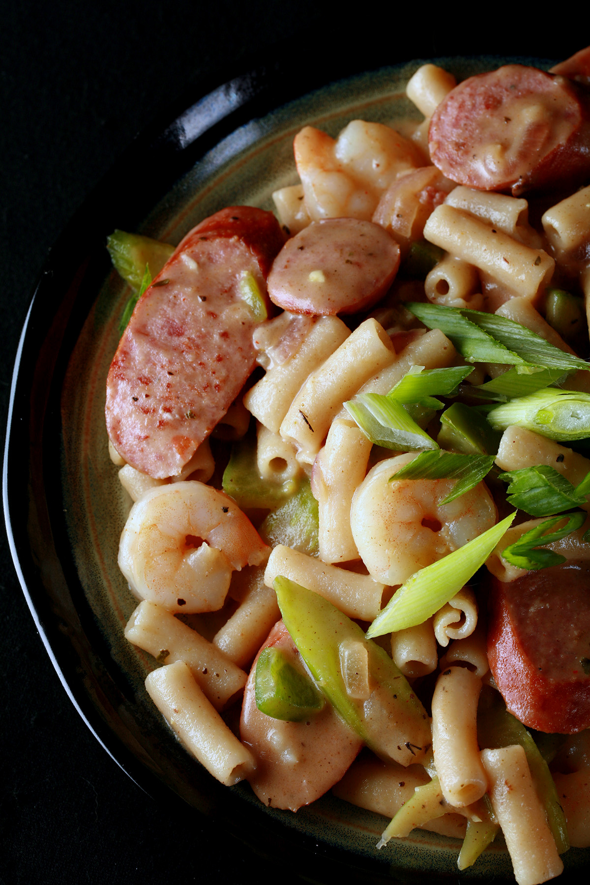 A plate of gluten-Free Creamy Creole Pasta. Shrimp, chicken, sausage, and celery are visible.