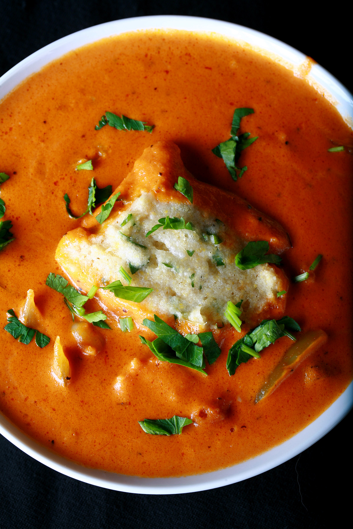 A bowl of gluten-free creamy creole soup with cornmeal dumplings.