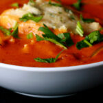 A bowl of gluten-free creamy creole soup with cornmeal dumplings.