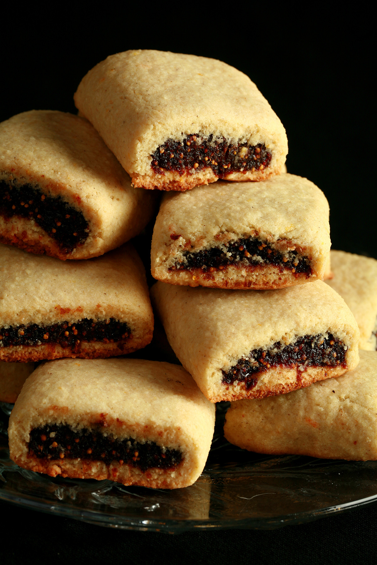A small glass plate piled high with gluten-free fig newton cookies.