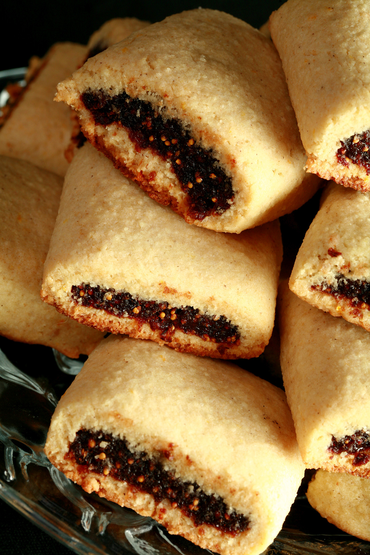 A small glass plate piled high with gluten-free fig newton cookies.