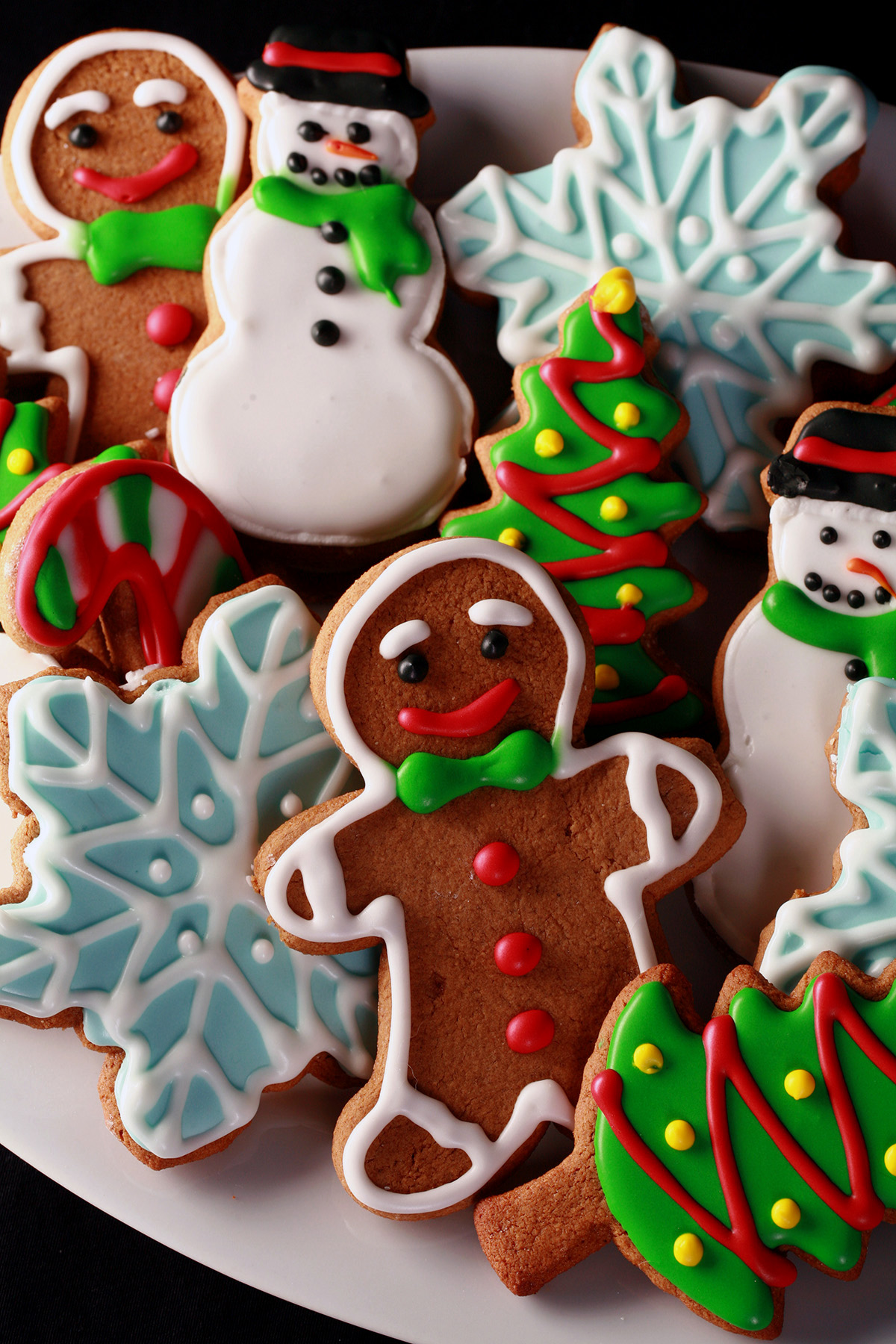 A plate of gluten-free gingerbread cookies, in various shapes, decorated with colourful royal icing.