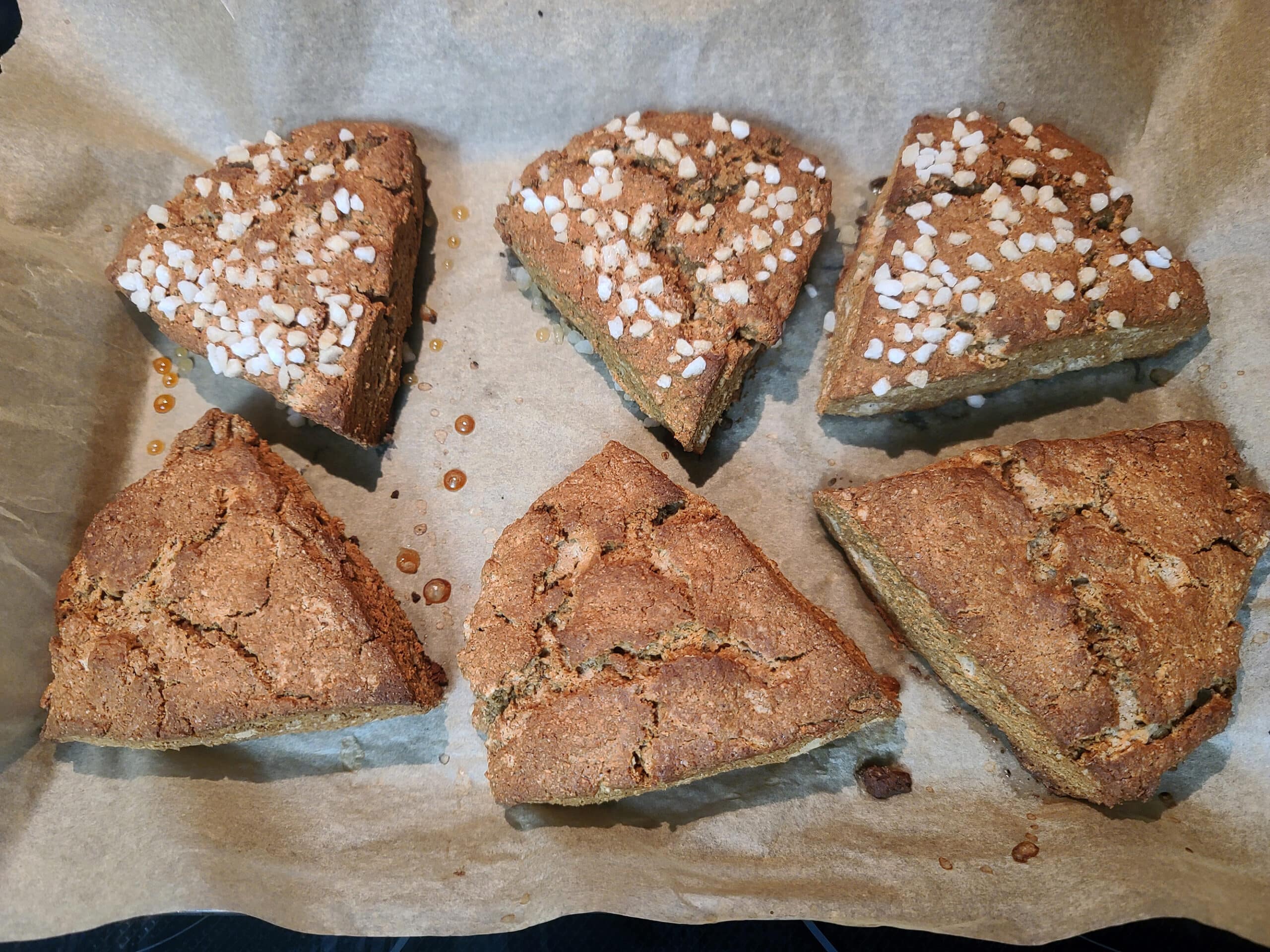 A pan of gluten free gingerbread scones, half with pearl sugar topping.