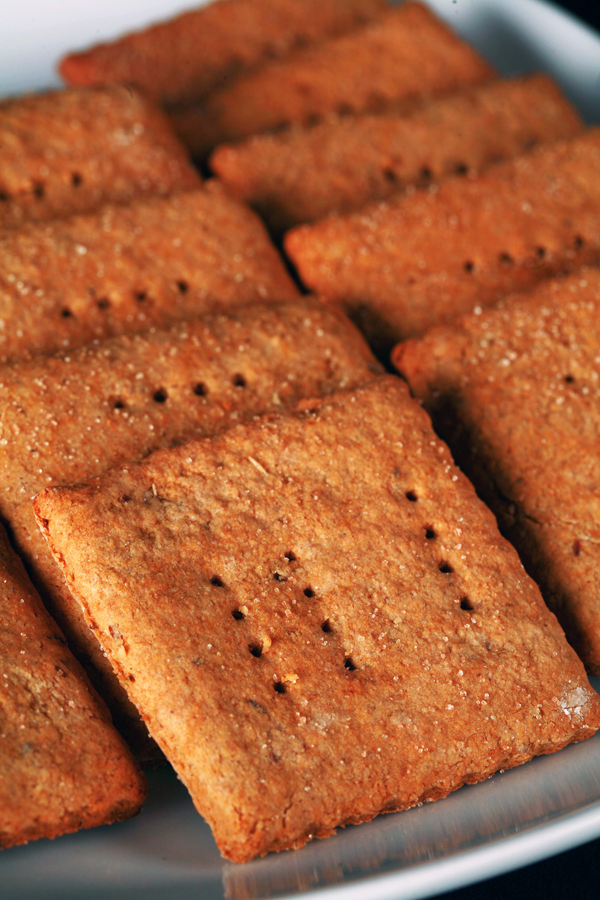 A white plate with rows of square shaped gluten-free graham crackers