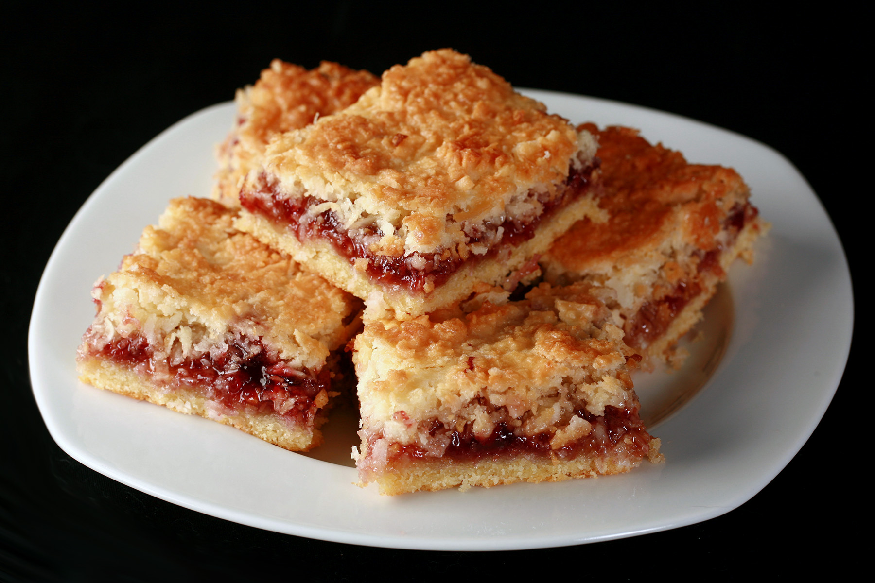 A plate of gluten-free raspberry coconut squaress.