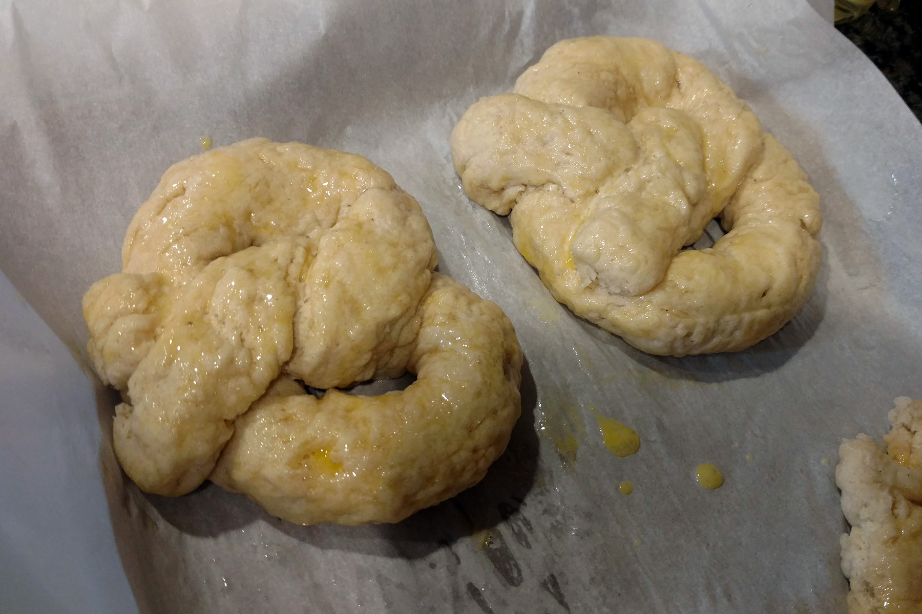 Two pretzels formed from the raw pretzel dough.
