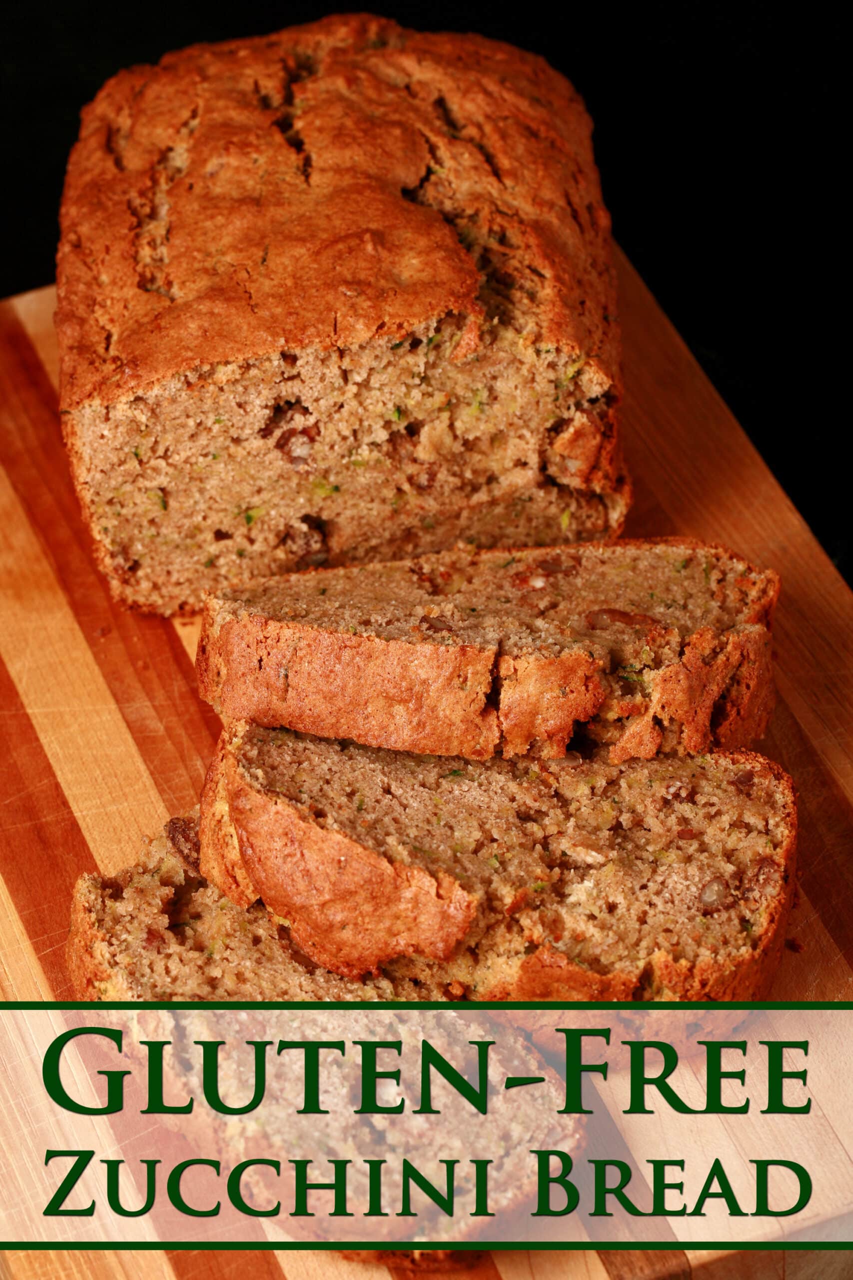 A sliced loaf of gluten free zucchini bread on a wooden cutting board.