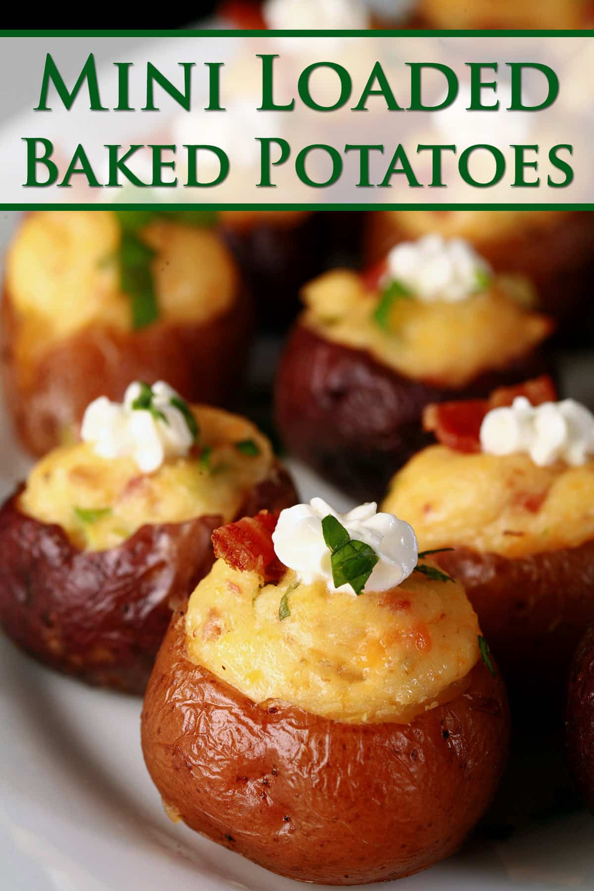 A party platter of loaded mini baked potatoes, topped with sour cream, bacon, and green onion.