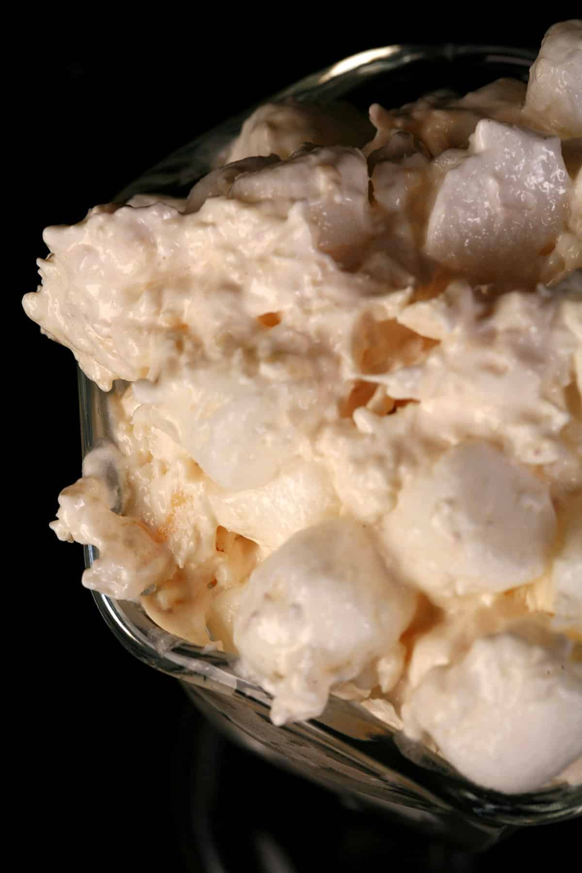 A close up photo of a serving of pina colada fluff in a tulip glass.