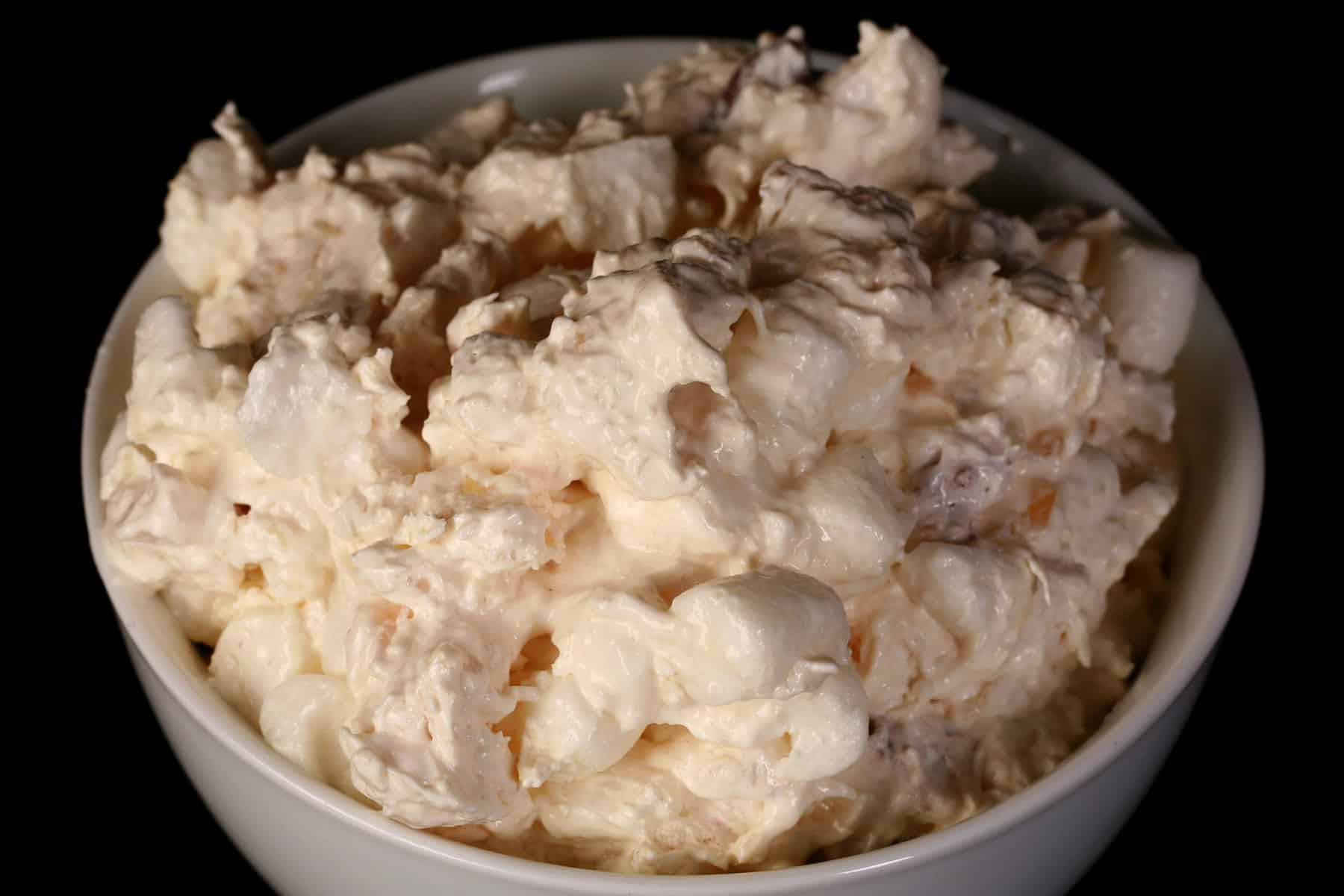 A close up photo of a serving of pina colada fluff in a tulip glass.