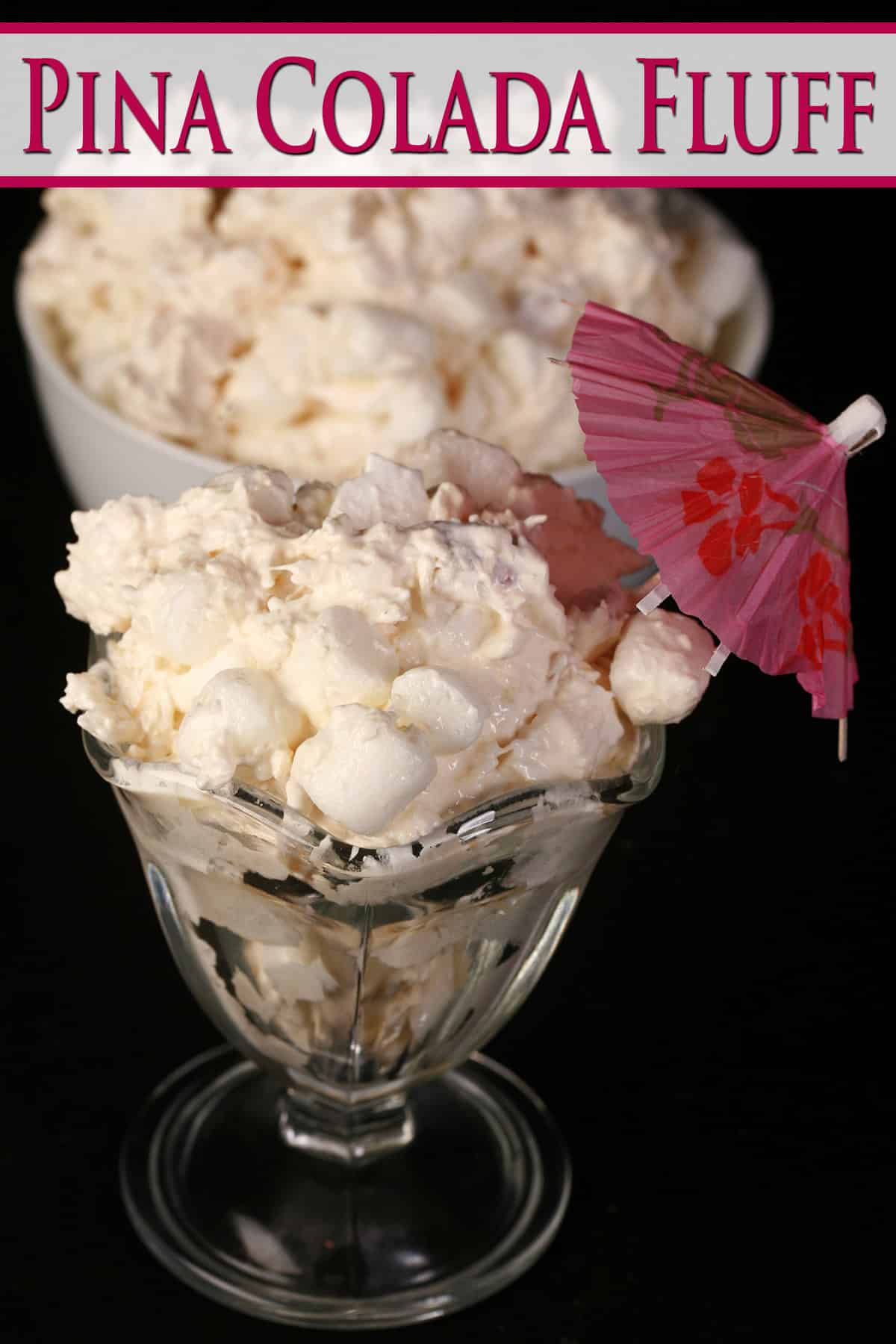 Pina colada fluff in a tulip glass with a pink cocktail umbrella sticking out.