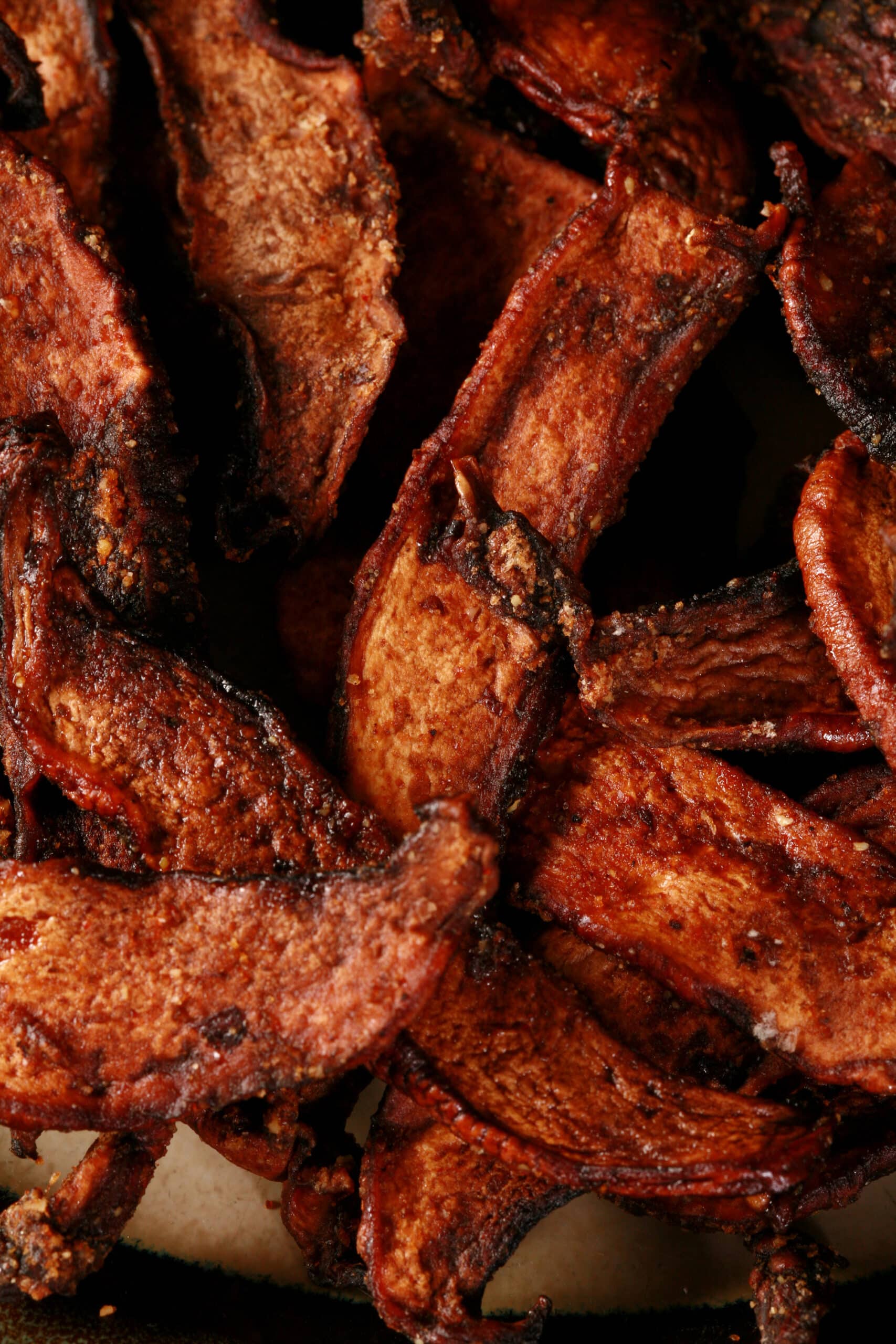 A plate of homemade mushroom jerky made from portabello mushroom slices.
