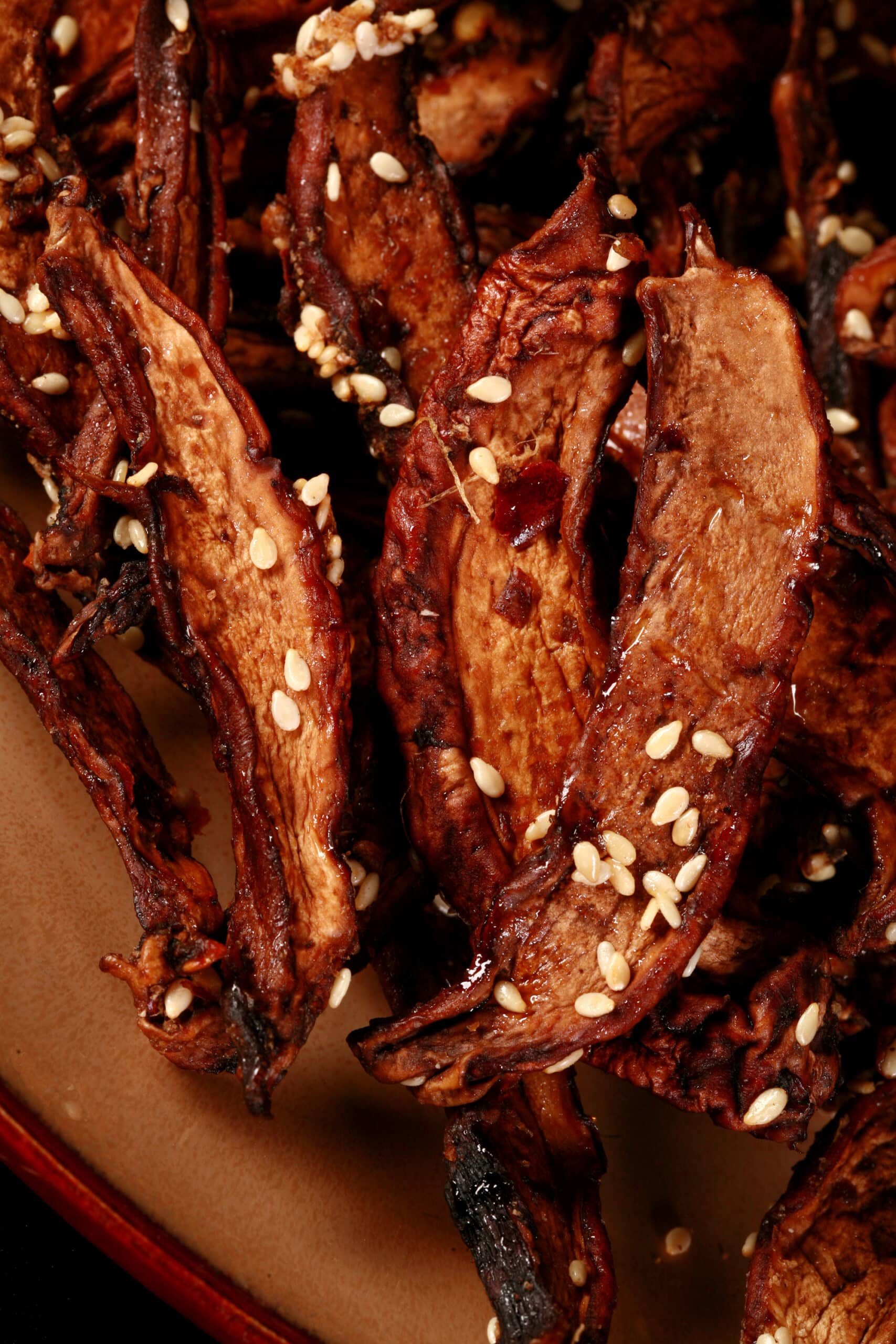 A plate of homemade mushroom jerky made from portabello mushroom slices. This batch has sesame seeds visible.