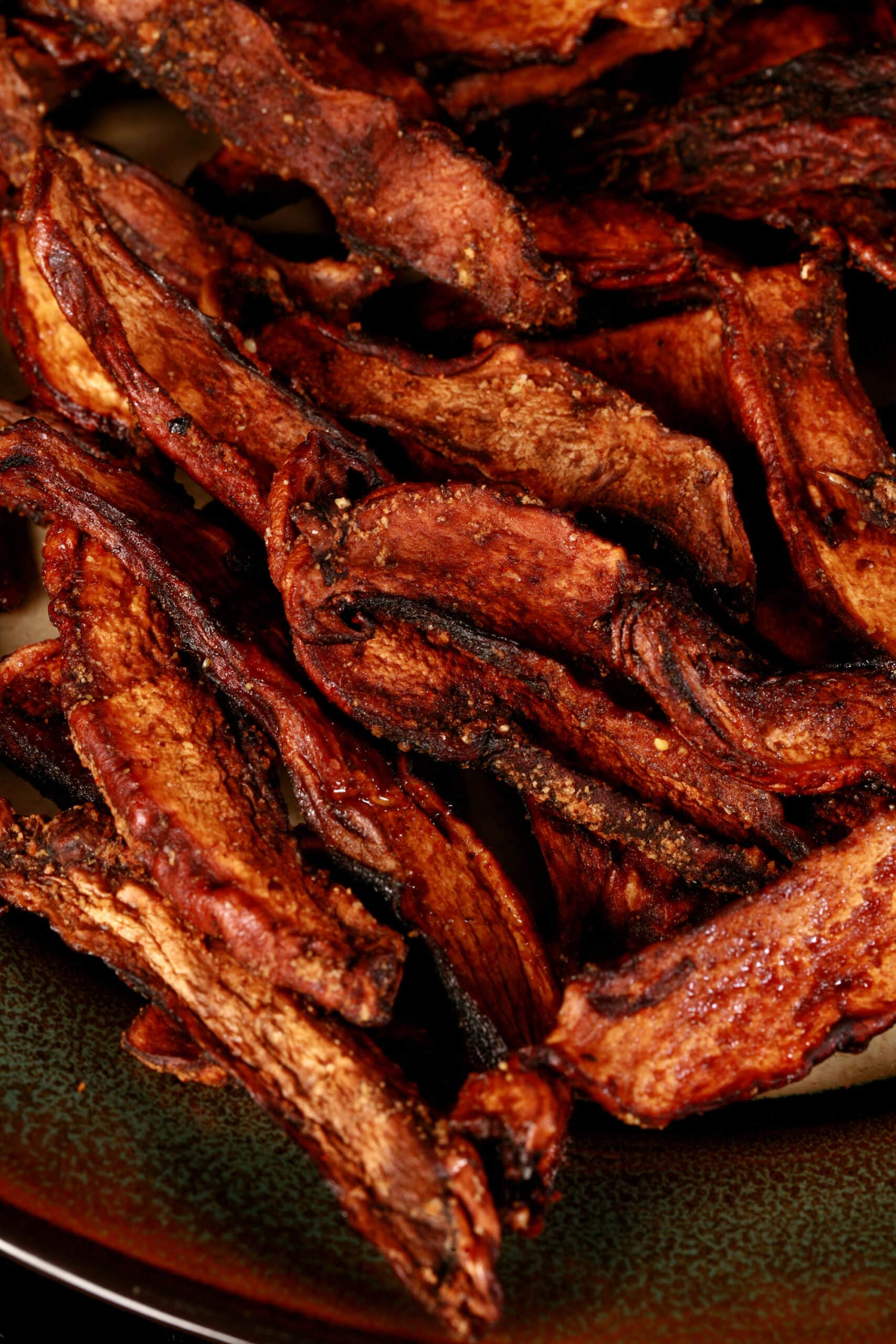 A plate of homemade mushroom jerky made from portabello mushroom slices.