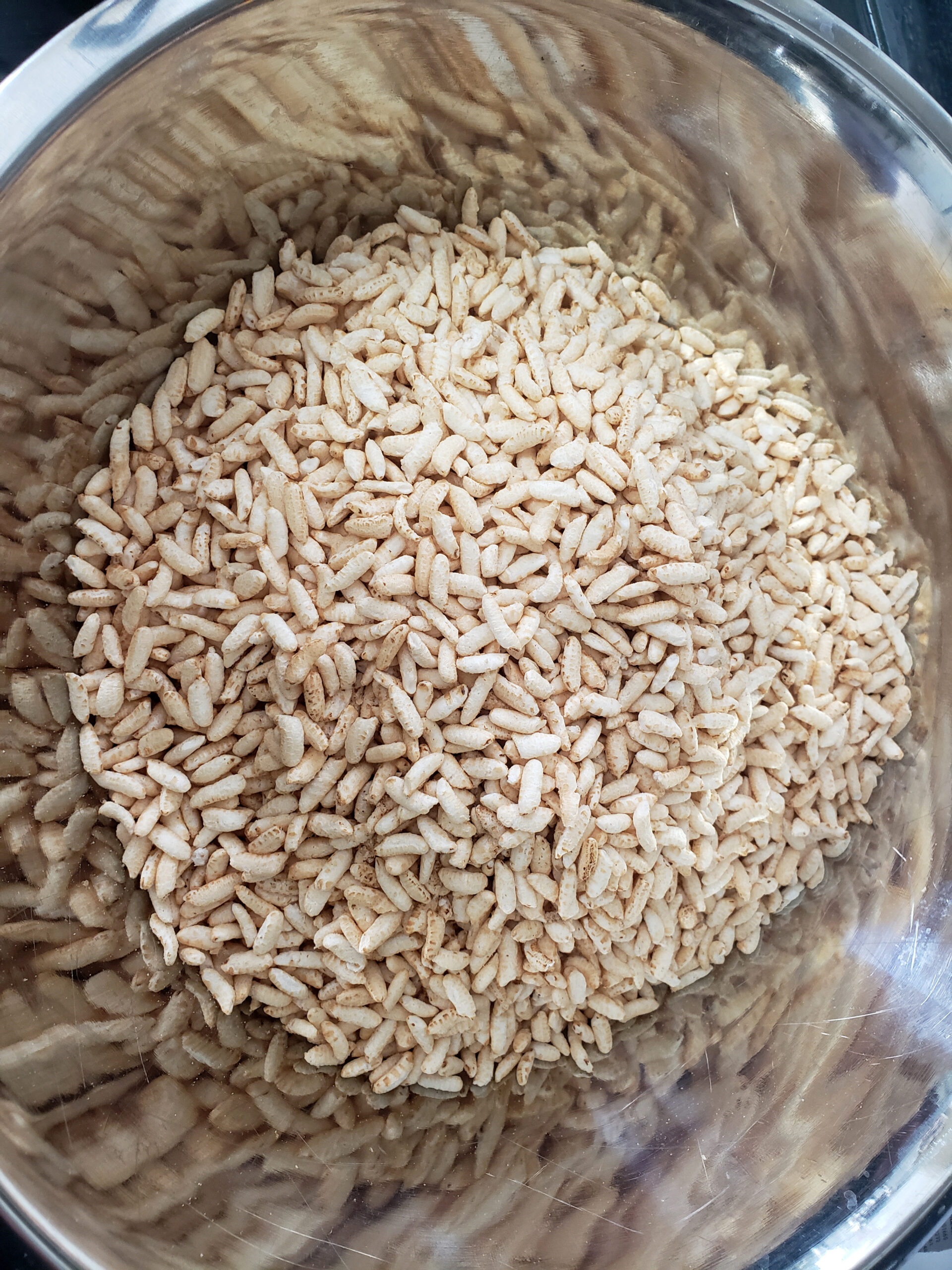 A large mixing bowl full of puffed rice cereal