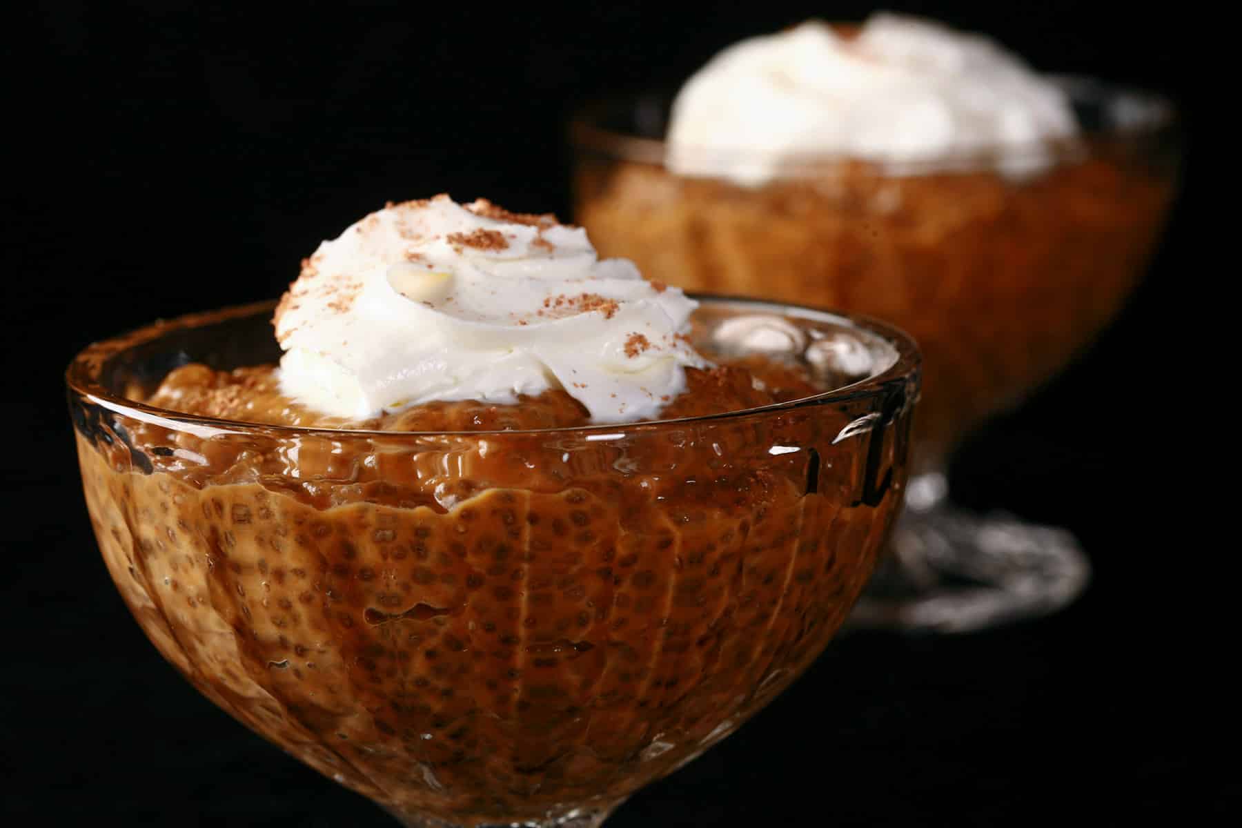 Pumpkin Pie Chia Pudding in a glass cup, topped with whipped cream and nutmeg.