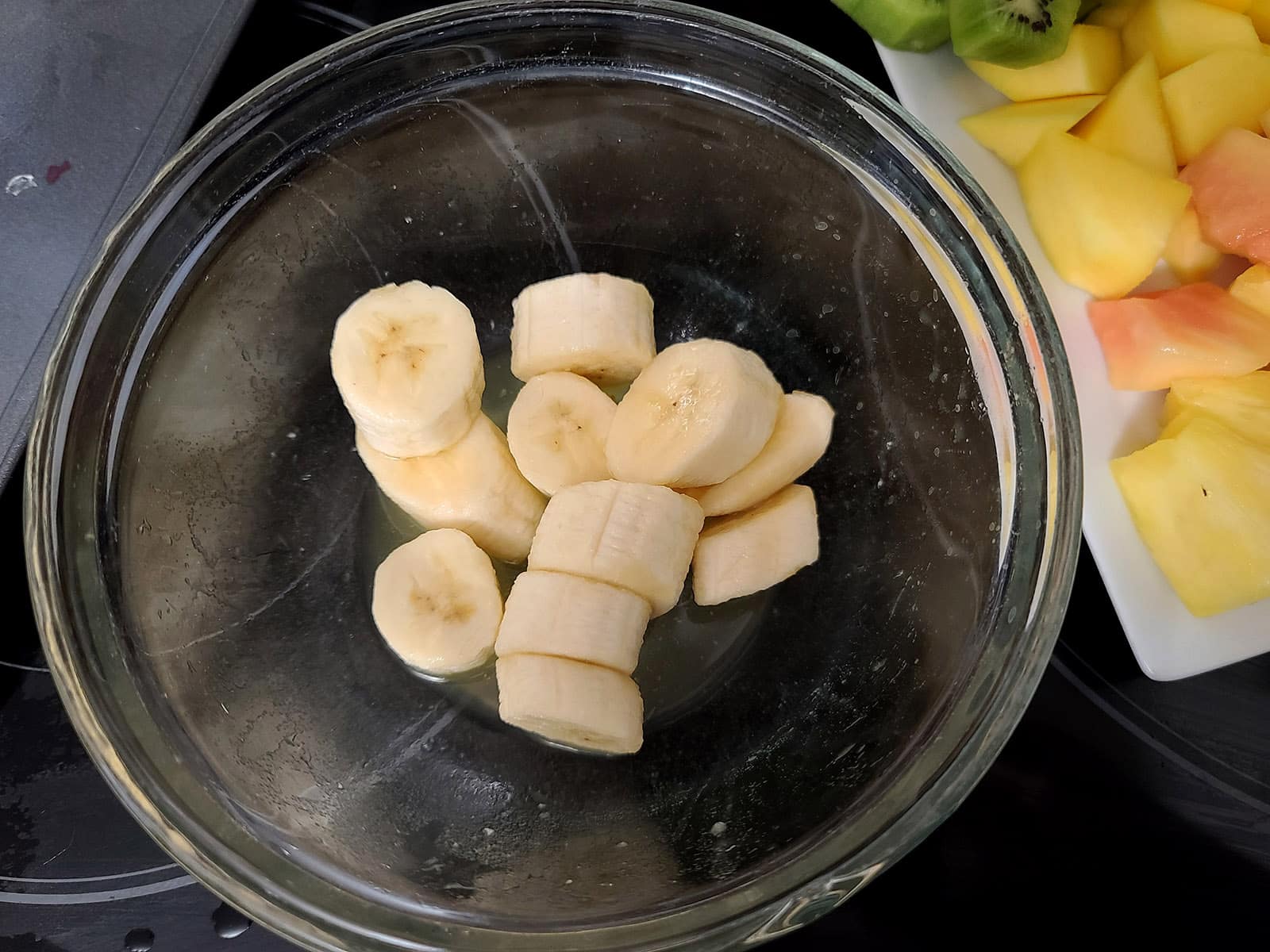 Sliced bananas in a bowl with lemon juice.