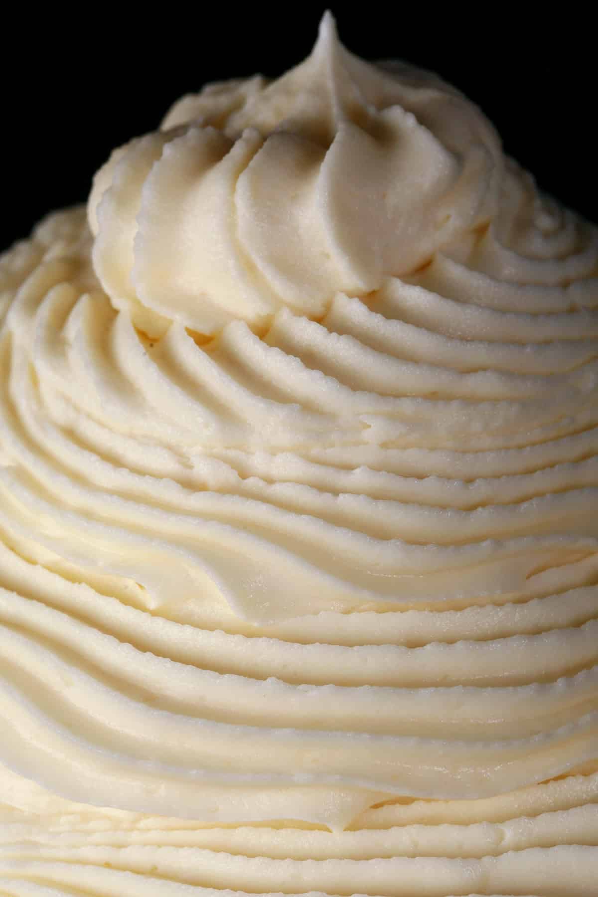 A tall swirl of whipped white chocolate ganache in a small bowl.